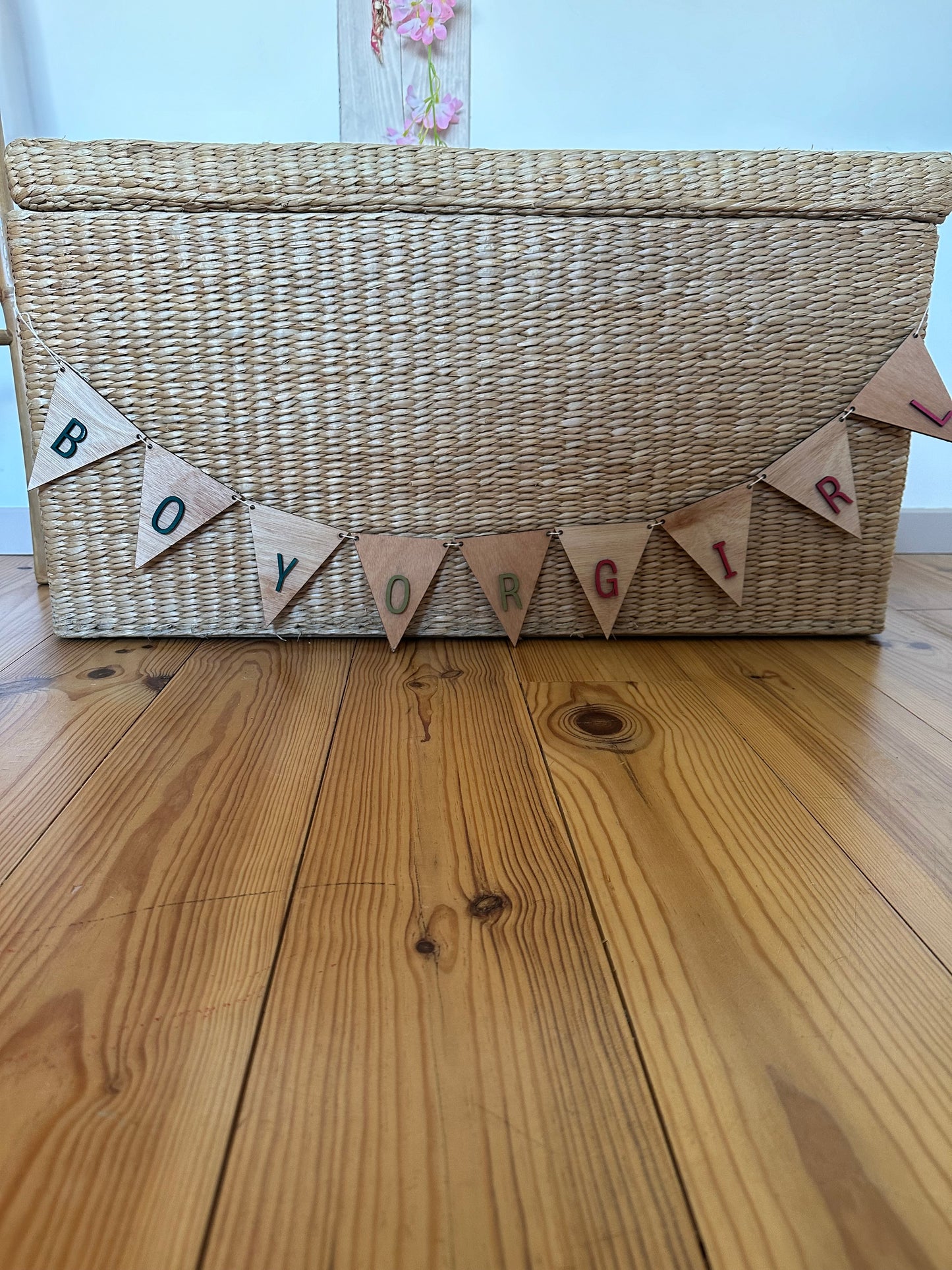 panier sur laquelle est suspendue guirlande "boy or girl" : lettres fixées sur des fanions