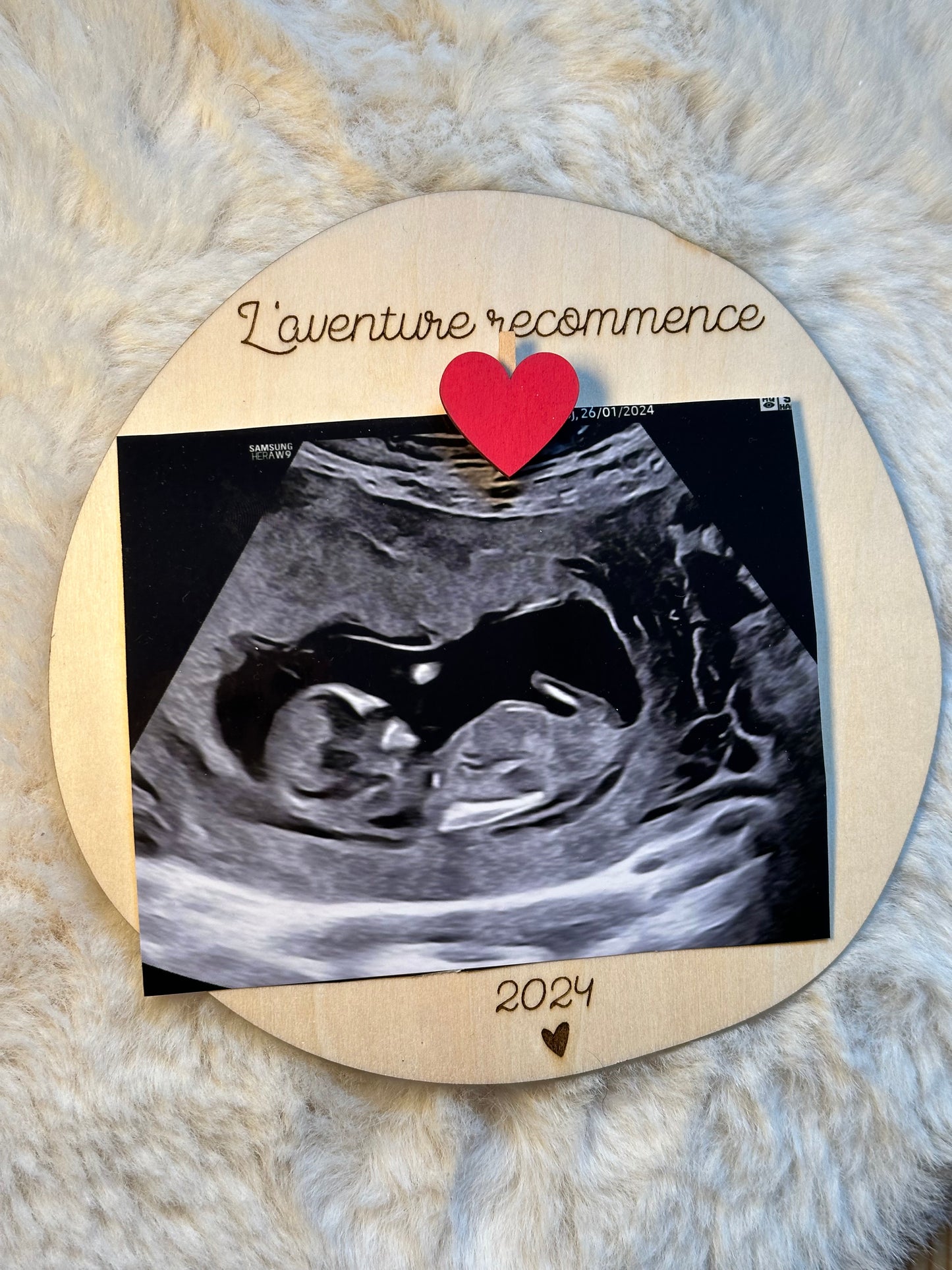 Carte en bois annonce "l'aventure recommence" avec une échographie épinglée avec une pince à linge coeur