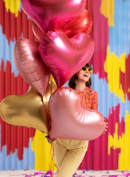femme heureuse avec un bouquet de ballons en forme de coeur