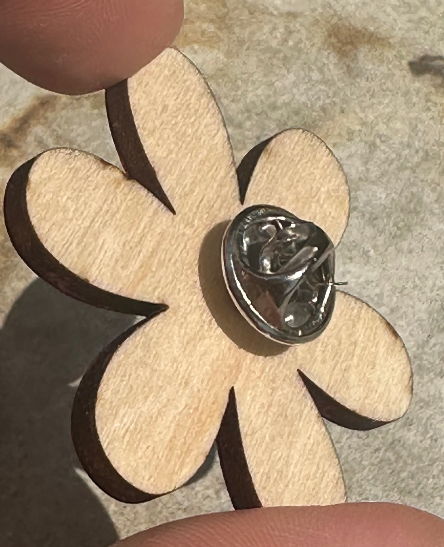verso du pins en forme de fleur en bois