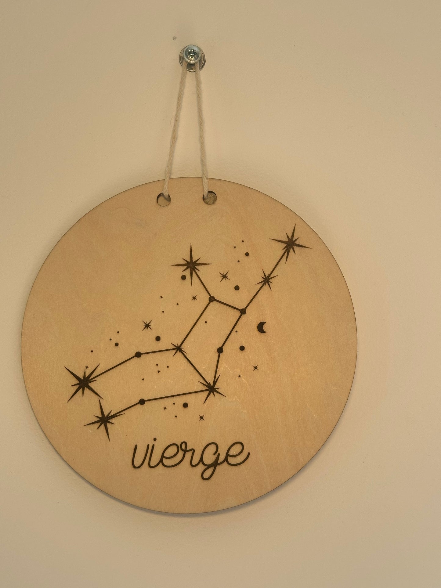 constellation et signe astrologique gravés sur un disque en bois