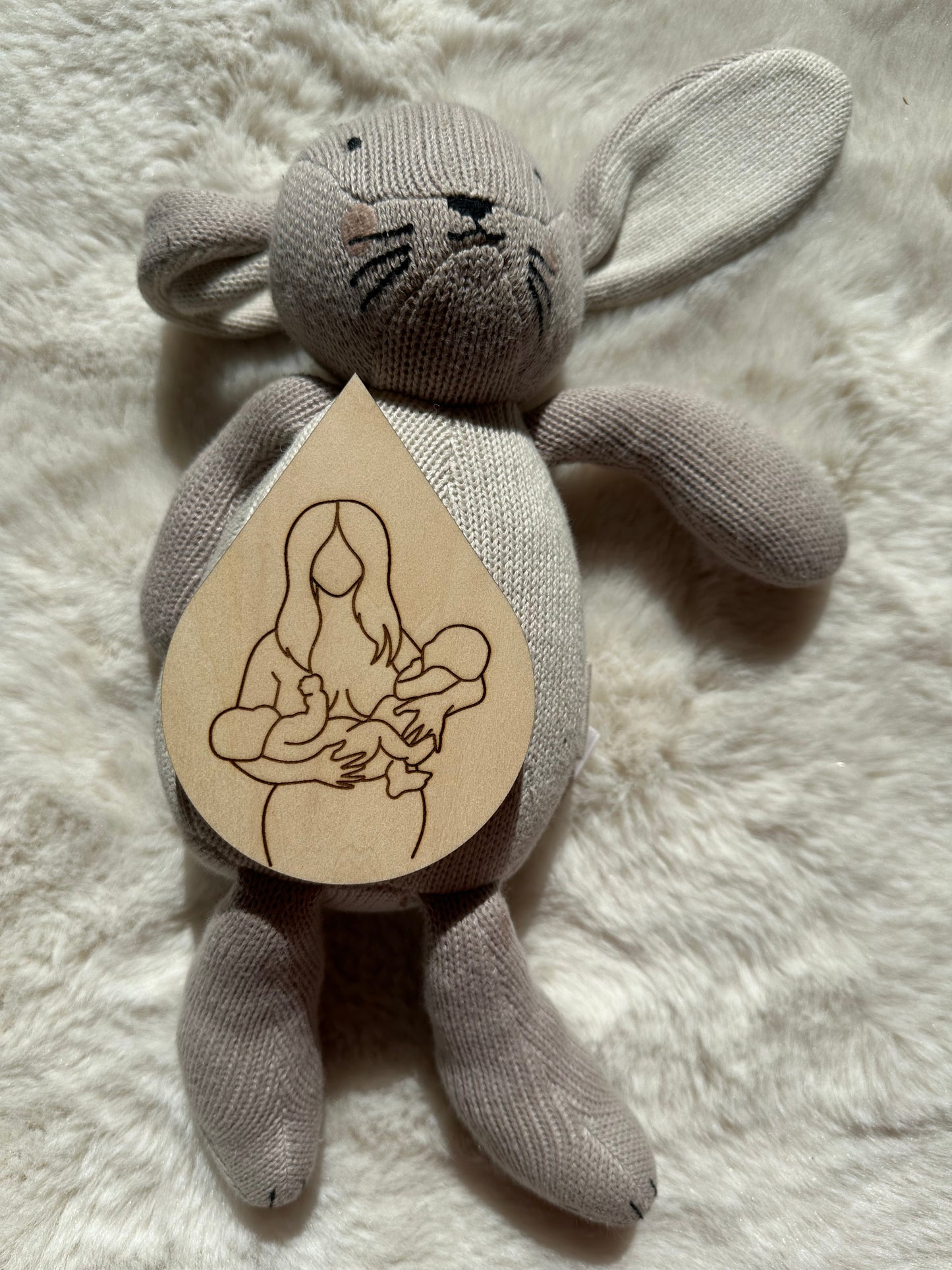 carte allaitement en forme de goutte de lait avec un dessin d'une femme allaitant 2 bébés. Carte en bois posée sur une peluche lapin