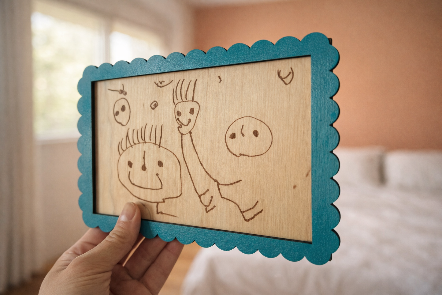 dessin enfantin de bonhommes reproduit sur une carte en bois et encadré