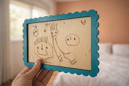 dessin enfantin de bonhommes reproduit sur une carte en bois et encadré