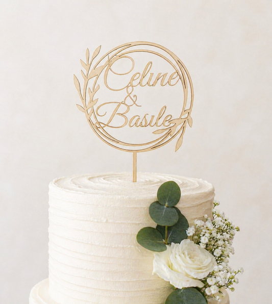 cake topper en bois posé sur un gâteau de mariage et personnalisé avec les prénoms des mariés "Céline & Basile". Cake topper sur le gâteau blanc décoré de fleurs