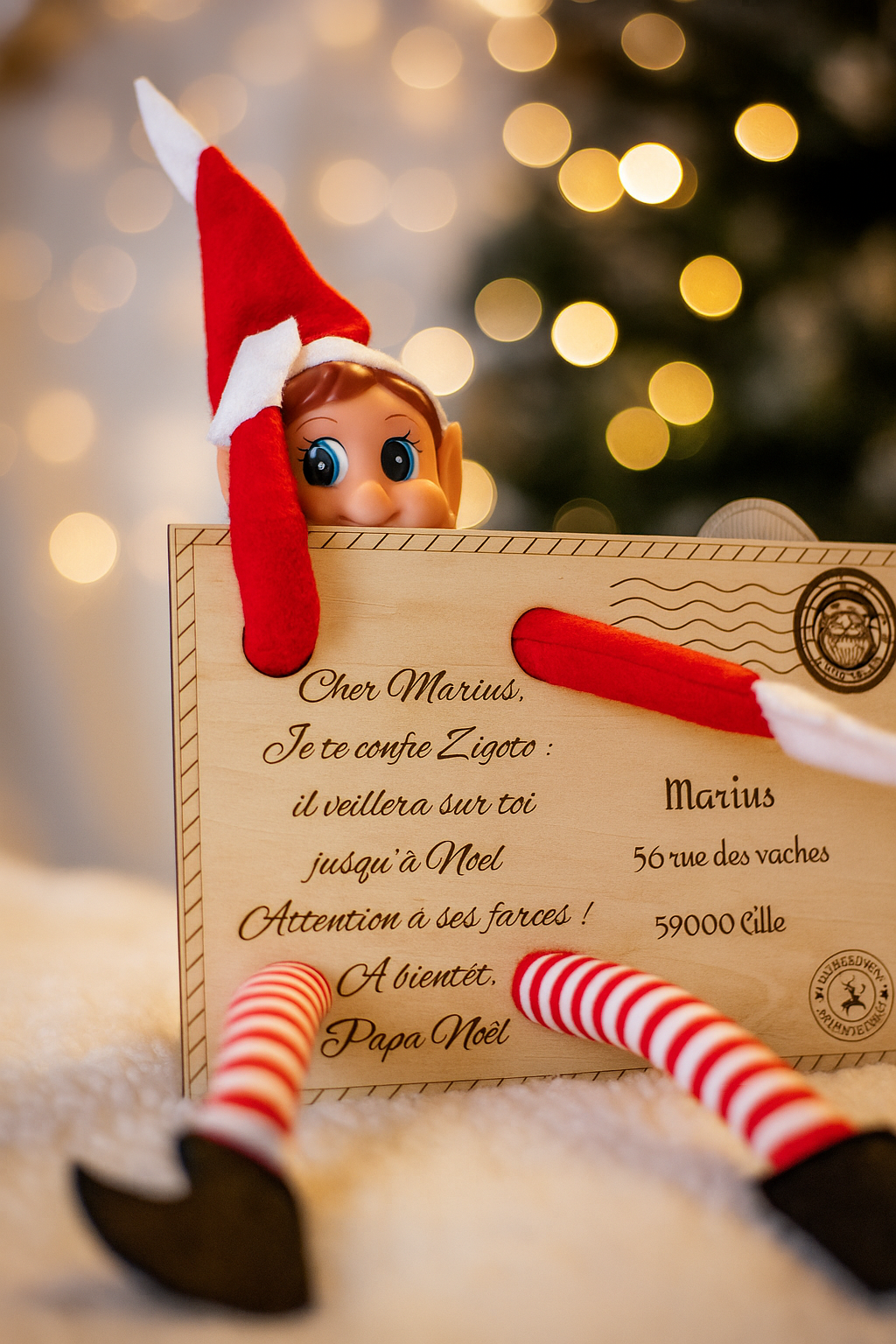 une lettre personnalisée avec encoches dans lesquelles les bras et jambes du lutin sont glissées,