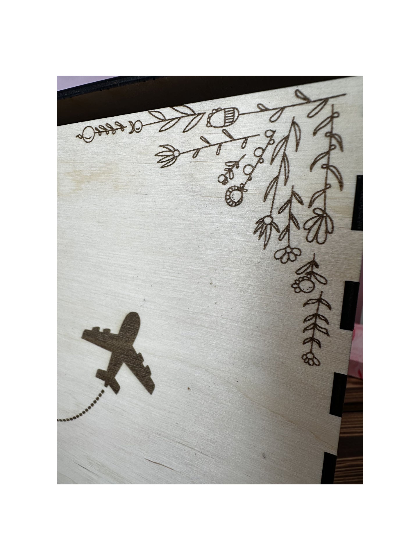 détail de l'urne en bois mariage : fleurs dessinées et gravées, un avion gravé sur le bois