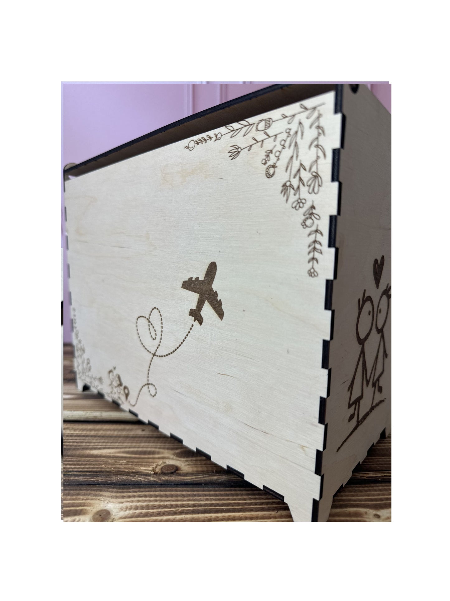 dos de l'urne gravé : un avion dessinant un coeur et des fleurs qui ornent l'urne en bois mariage