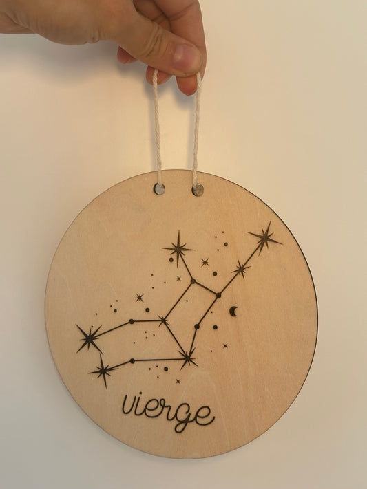 constellation et signe astrologique gravés sur un disque en bois
