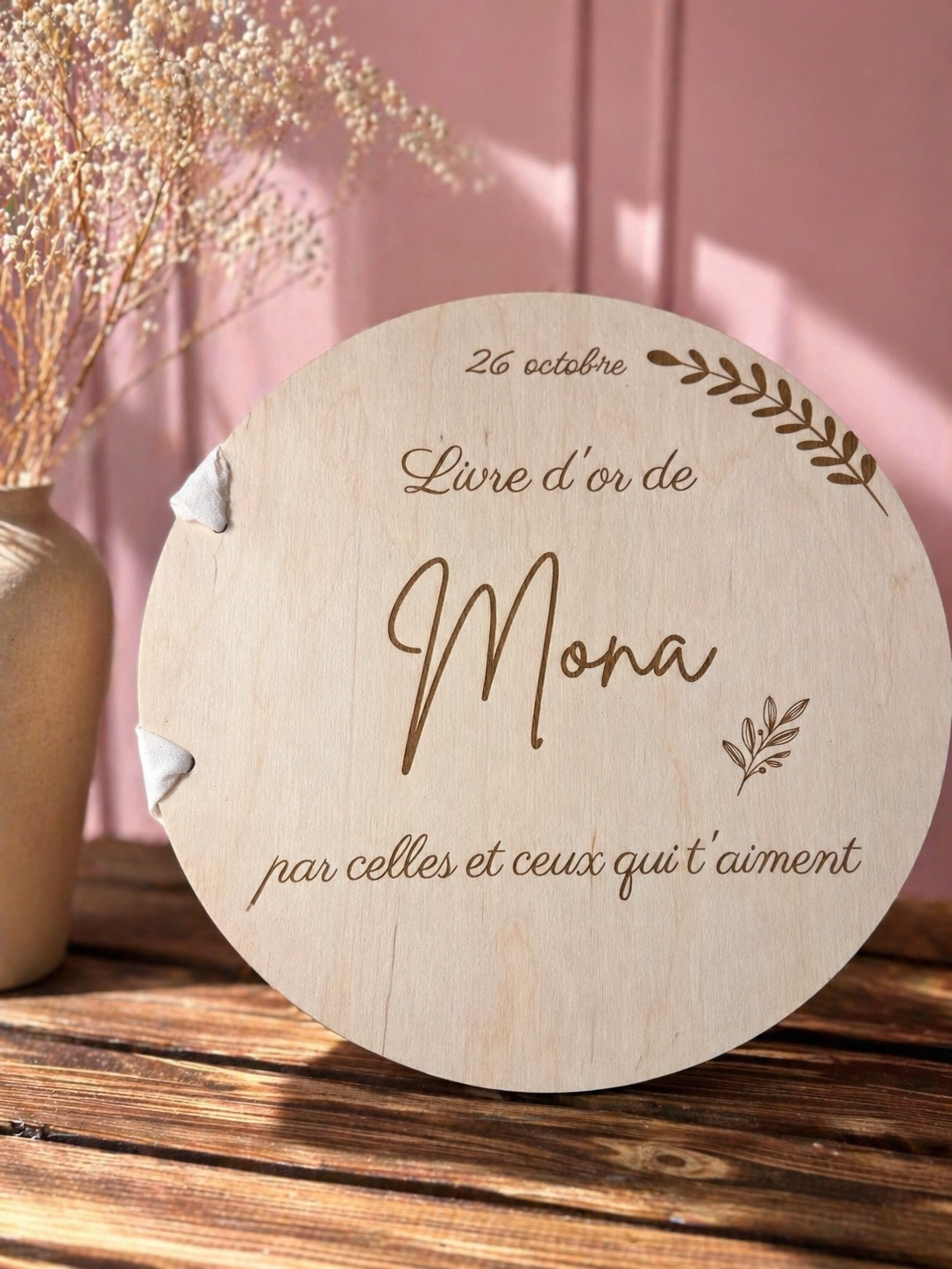 Livre d’or en bois personnalisé avec prénom gravé, reliure ruban blanc, "26 octobre, Livre d'or de Mona par celles et ceux qui t''aiment" gravé, ambiance lumineuse et naturelle.