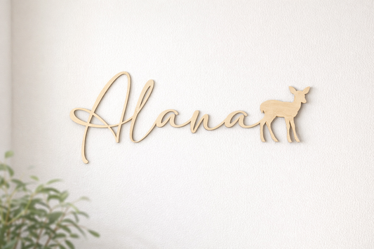 prénom en bois découpé au laser et se terminant par un faon, prénom "Alana" posé sur un mur blanc