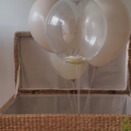 bouquet de ballons nudes s'envolant, au bout un disque en bois "c'est un garçon" est suspendu