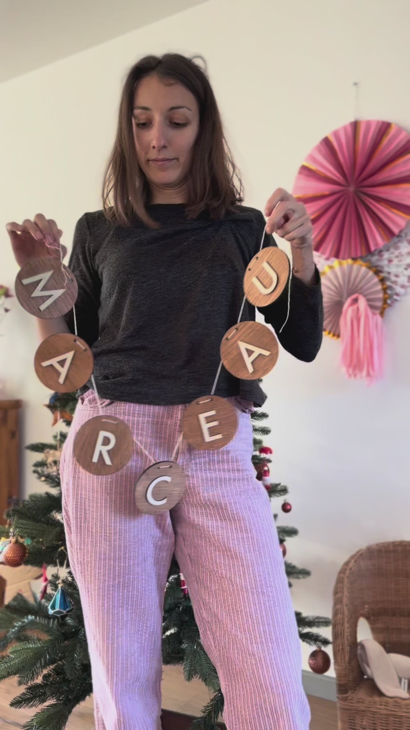 Guirlande prénom en bois composée de disques ronds suspendus par une ficelle, lettres blanches formant le prénom Marceau, posée sur un sol imitation parquet bois clair.